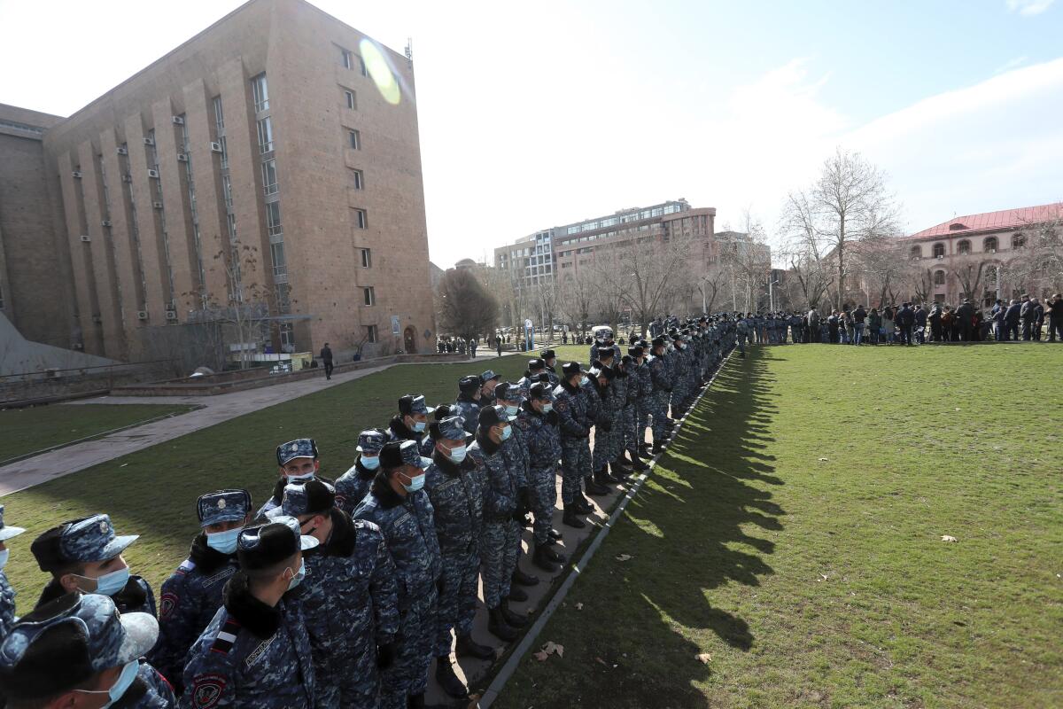 Police form a line outside a building.