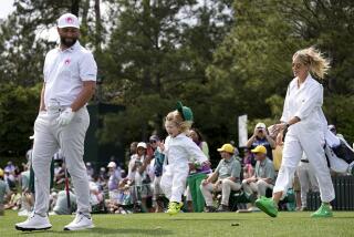 Jon Rahm, of Spain, walks with his wife, Kelley Cahill, and son, Kepa, during the par-3 contest at the Masters 