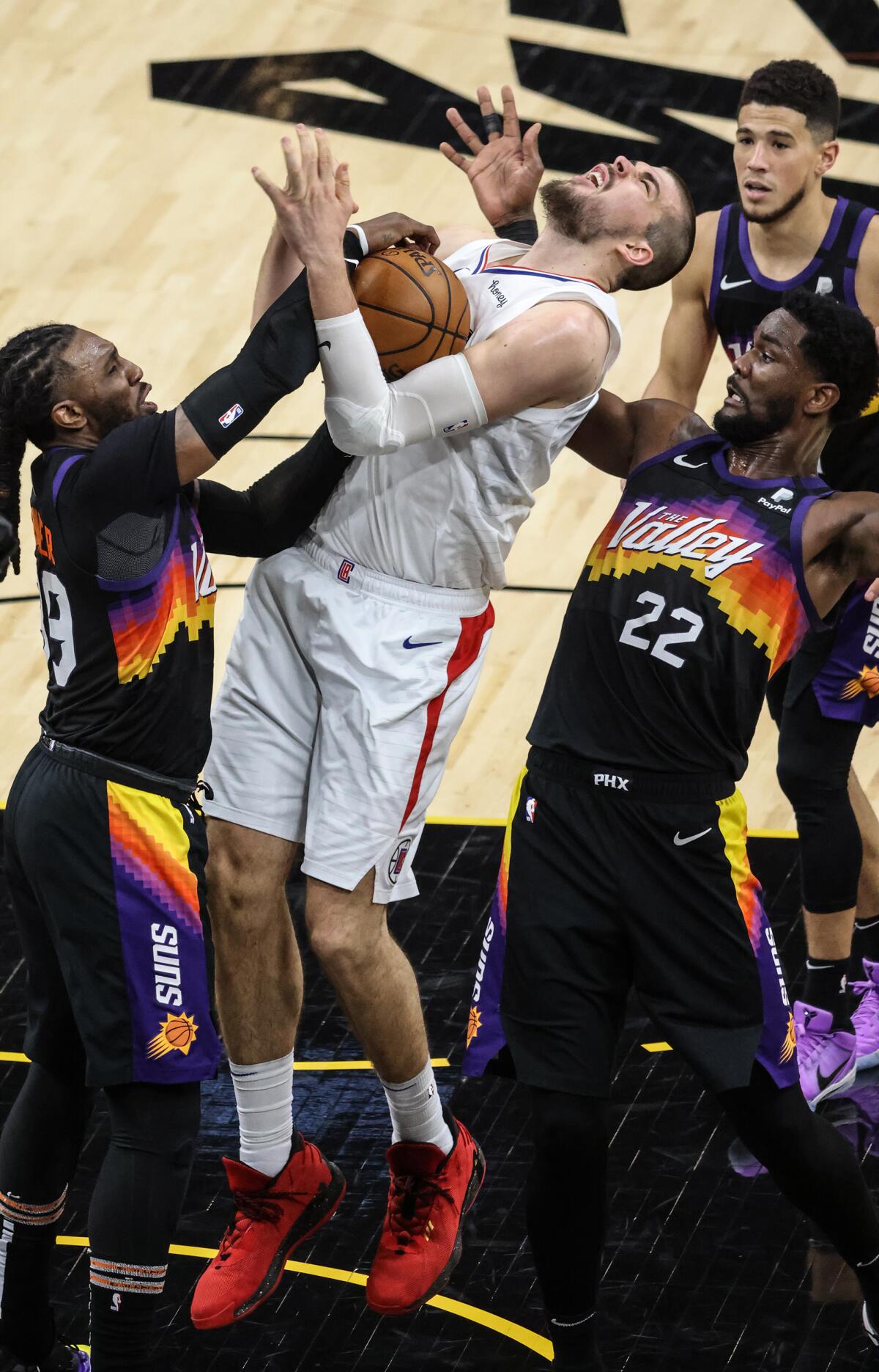 Clippers center Ivica Zubac tries to score inside against Phoenix’s Jae Crowder, left, and Deandre Ayton in Game 2.