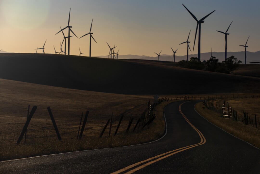 A road leads to wind turbines.