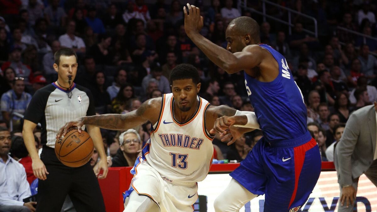 Clippers forward Luc Mbah a Moute tries to cut off a drive by Thunder forward Paul George on Friday night.