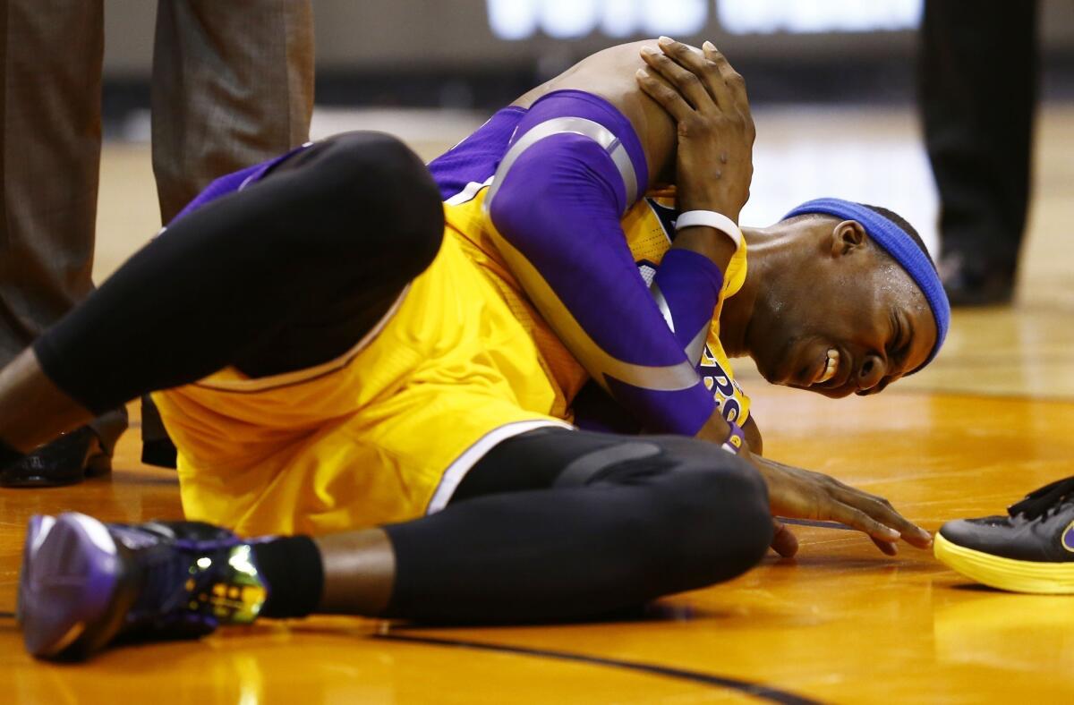 Lakers center Dwight Howard grabs his shoulder in pain during a game against the Phoenix Suns.