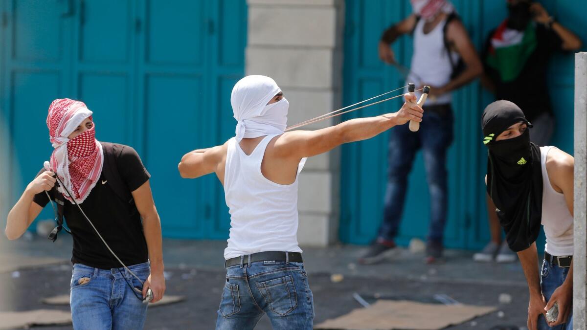 A Palestinian uses a slingshot against Israeli soldiers during clashes in the West Bank city of Bethlehem on July 21.