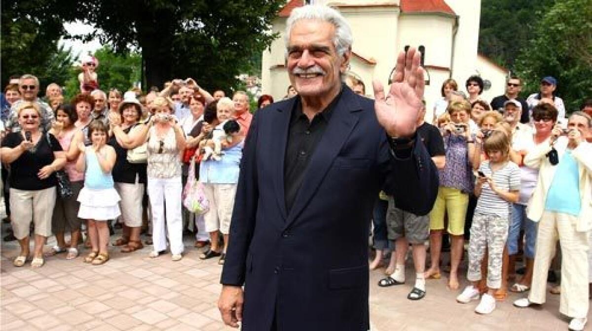 Egyptian film actor Omar Sharif greets photographers and onlookers at Trencianske Teplice, Slovakia, last month at the international film festival Artfilm