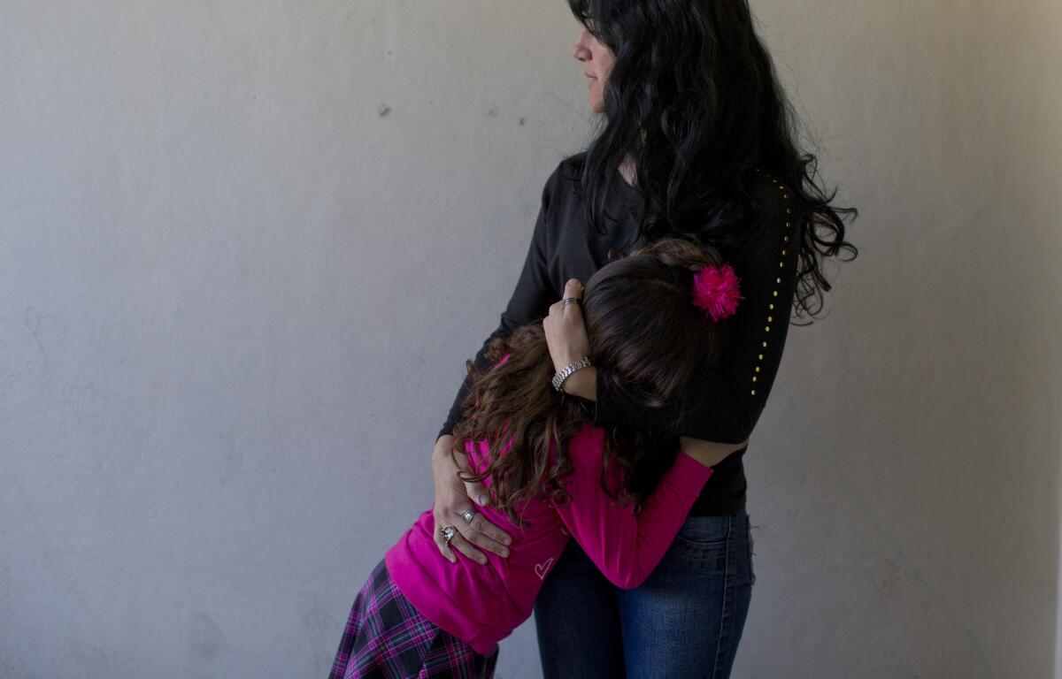 En esta imagen, tomada el 29 de septiembre de 2015, Luana abraza a su madre, Gabriela Mansilla, en su casa en Merlo, Argentina. Mansilla dice que siempre hubo claras diferencias entre sus dos hijos mellizos. Manuel, el nombre que se le dio a Luana al nacer, se ponía camisetas en la cabeza, aparentemente fingiendo que tenía cabello largo. Le gustaban las muñecas. Sus personajes preferidos en las películas eran las princesas y las sirenas. Entre sus primeras palabras figuró la frase "yo nena". (Foto AP/Natacha Pisarenko)