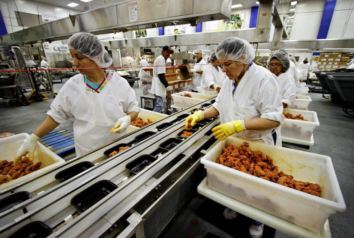 Workers in an L.A. Unified kitchen pack student meals in 2011. The district has joined five other major urban school districts in a push to make wholesome food and eco-friendly practices a national standard.