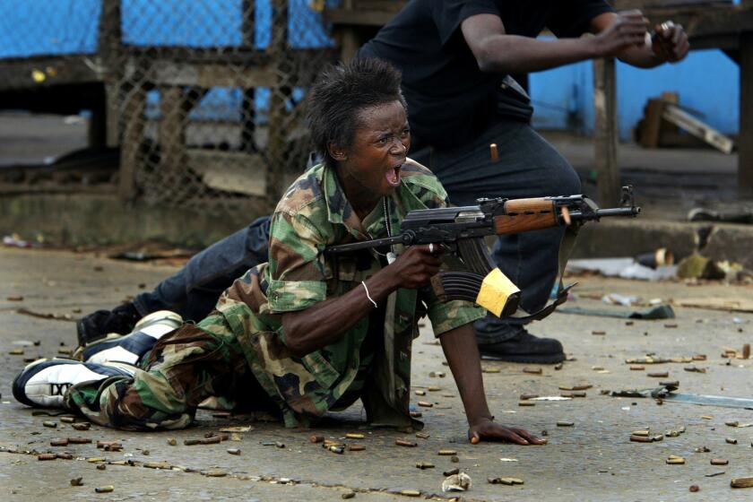 FIRING BACK: A government soldier defends a bridge in central Monrovia where a standoff between rebel and government forces held the city under siege.