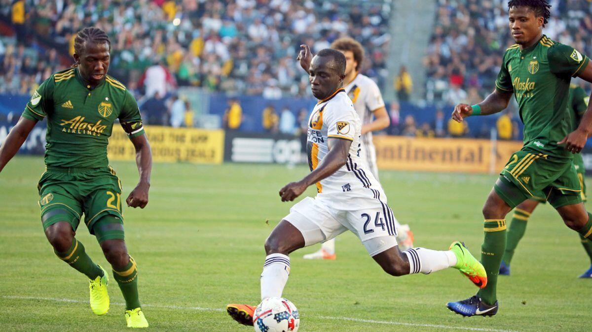 Galaxy midfielder Emmanuel Boateng (24) drives the ball as Portland Timbers midfielder Diego Chara (21) and defender Alvas Powell (2) pursue during the second half of a game March 12 at StubHub Center. The Timbers won 1-0. (AP Photo/Reed Saxon)