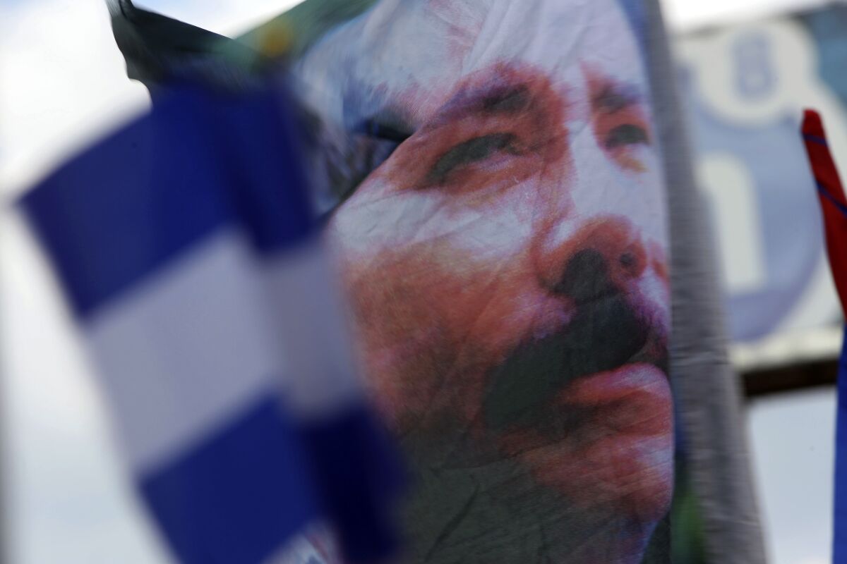 Un partidario del presidente de Nicaragua, Daniel Ortega, ondea una pancarta con una imagen de él, 