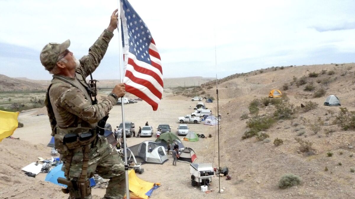 Jerry DeLemus fixes a U.S. flag near an armed militia camp in 2014 that rallied to the Bundy ranch to protect him from the U.S. government.
