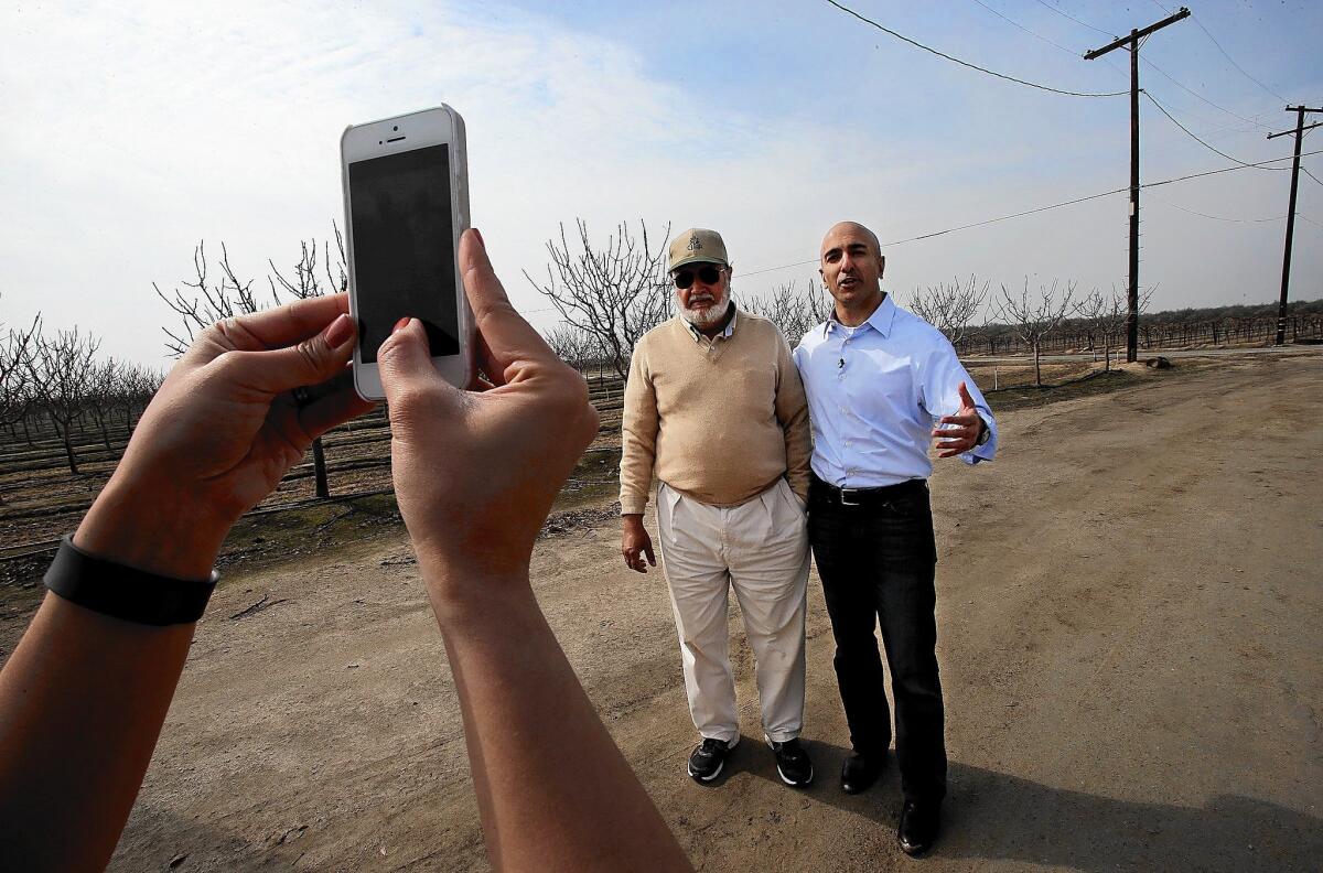 Neel Kashkari poses with Khalsa Farms owner Bir Dhillon in the Central Valley. Donors have started spending more than $650,000 to promote him.