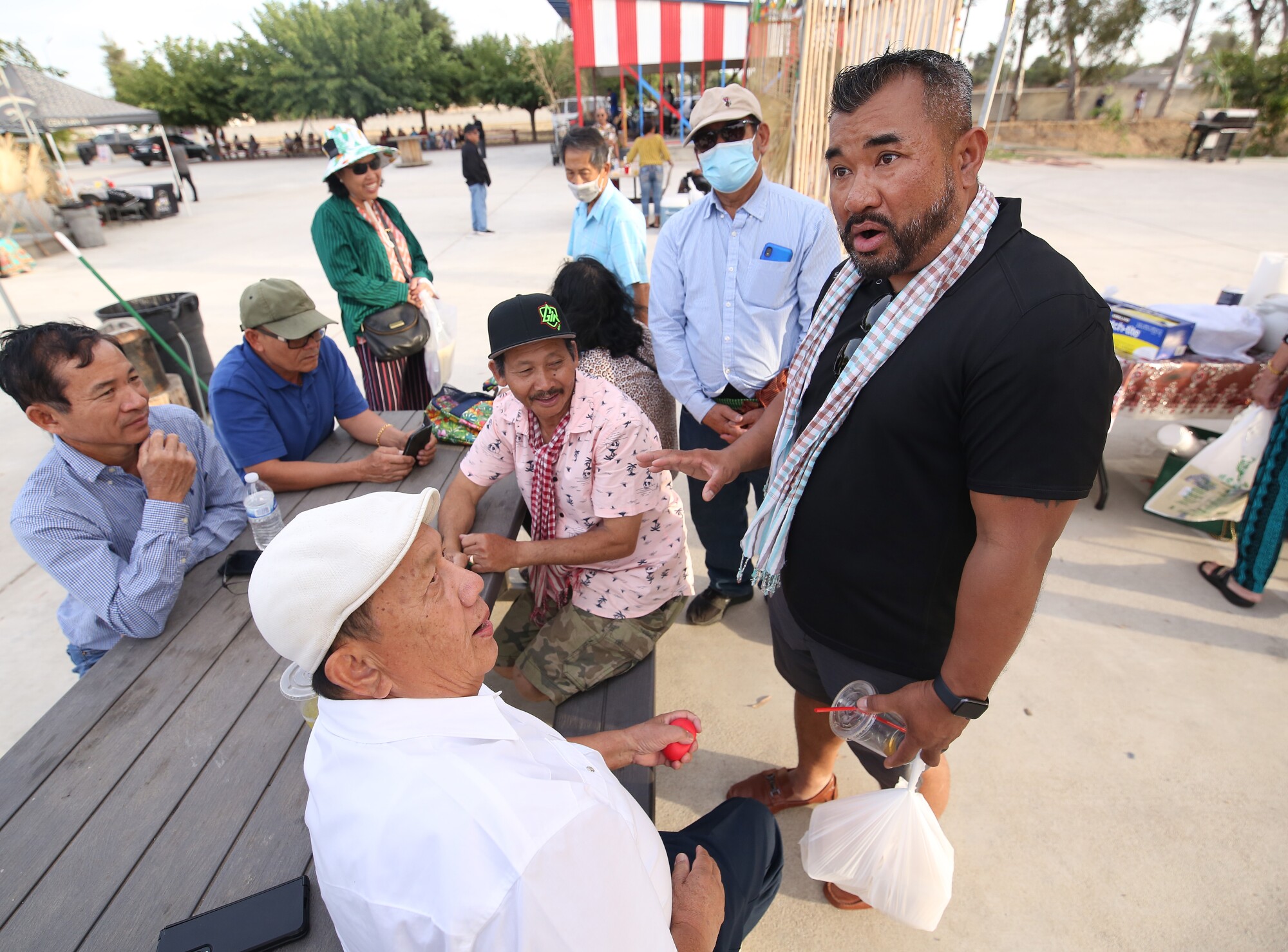Danny Kim talks to elders at a Cambodian night market.