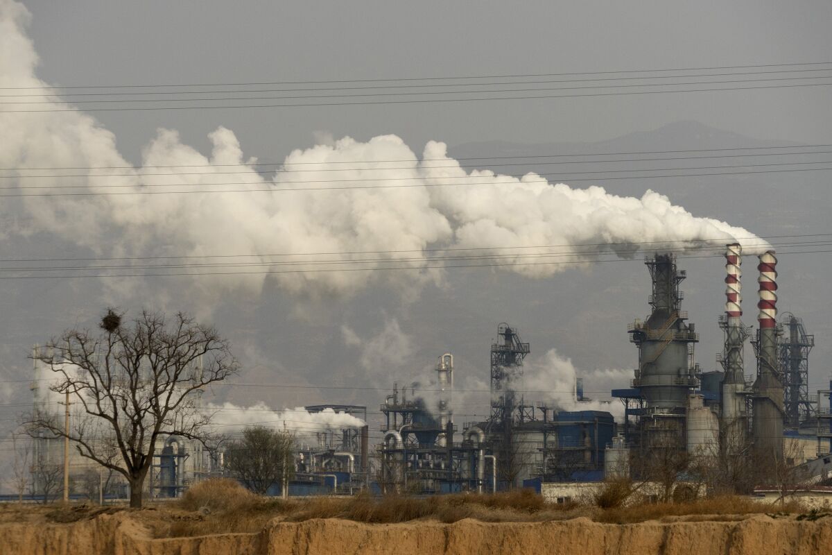 Smoke and steam rise from a coal processing plant in China, the world's top emitter of greenhouse gases.