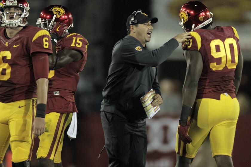 Trojans Coach Steve Sarkisian gives defensive tackle Claude Pelon a pat on the shoulder after a defensive stop in the first half against Cal.