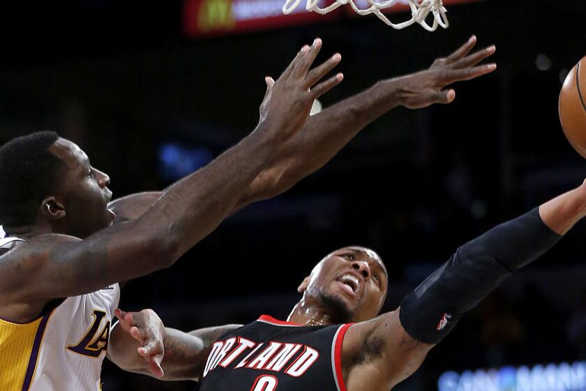 Lakers forward Brandon Bass can't prevent Portland Trail Blazers point guard Damian Lillard from scoring on a layup during a Nov. 22 game at Staples Center.