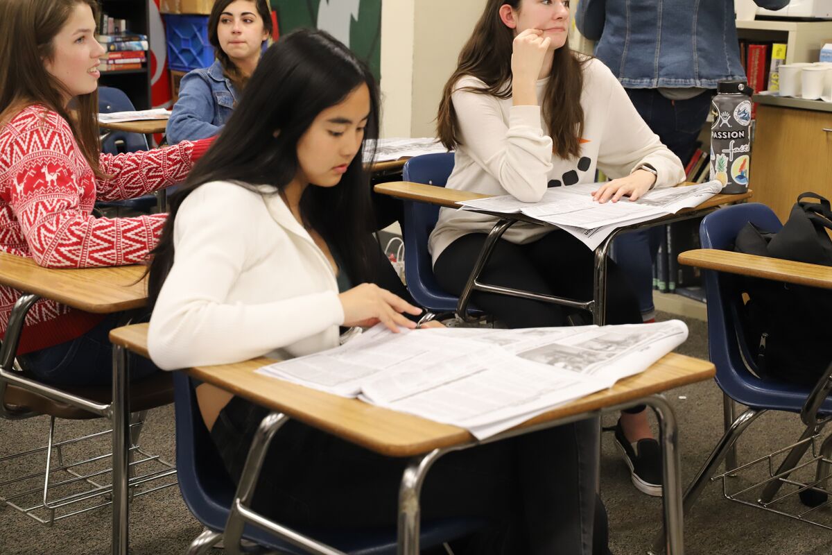 Poway High School student Vy Le peruses The Illiad newspaper during a critique. 