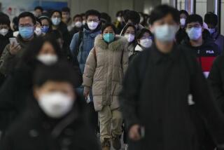 Masked commuters walk through a walkway in between two subway stations as they head to work during the morning rush hour in Beijing, Tuesday, Dec. 20, 2022. China continues to adapt to an easing of strict virus containment regulations. (AP Photo/Andy Wong)