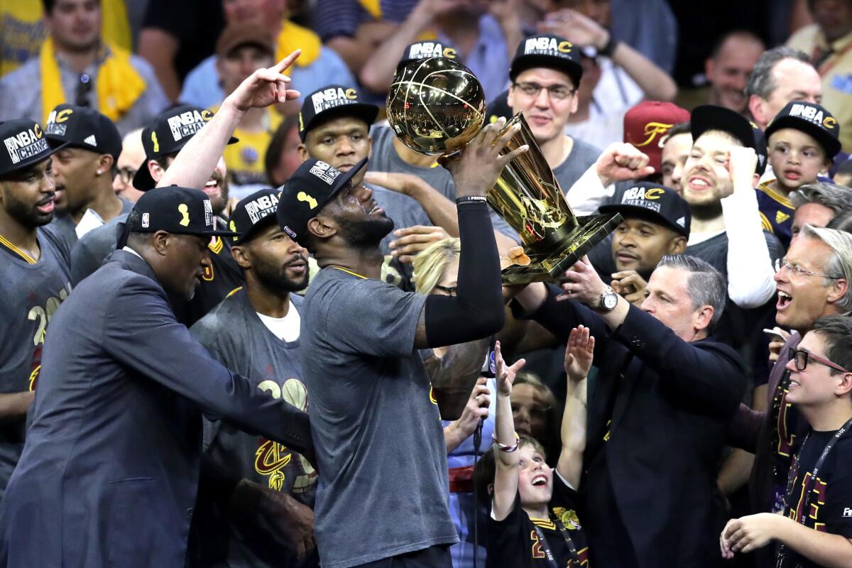 LeBron James holds the Larry O'Brien trophy after the Cleveland Cavaliers clinched their first NBA title on June 19.