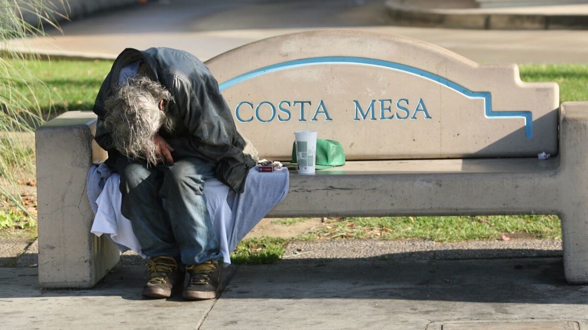 A homeless man sleeps on a bench near Wilson Street and Harbor Boulevard in 2008.