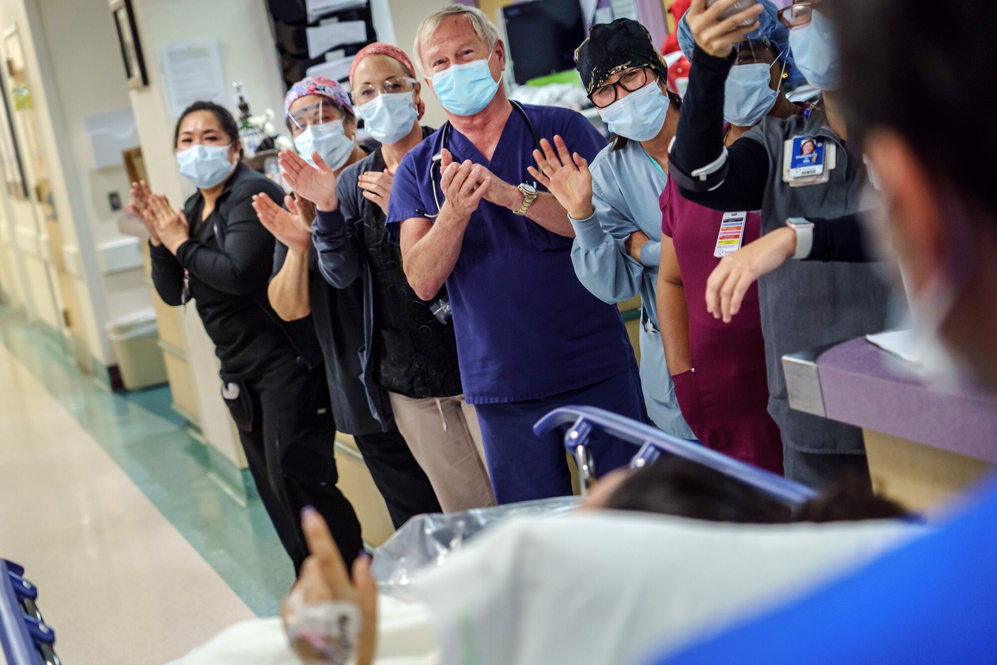 Healthcare workers celebrate as a patient is discharged from the ICU.