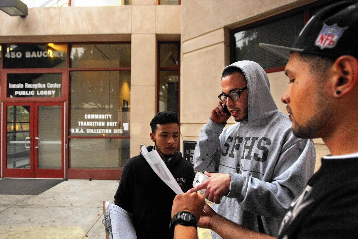 Bryan Juarez, 19, left, and Jose Garcia, 22, right, get Johnny Atencio, 21, to call county Supervisor Zev Yaroslovsky's office to request that he support the campaign of the group Coalition to End Sheriff Violence in L.A. Jails, shortly after Atencio was released from Men's Central Jail.