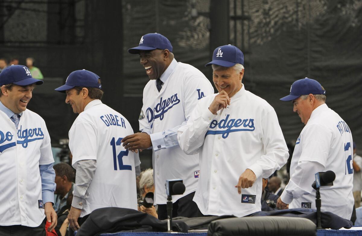The Dodgers new ownership group shares a laugh after being introduced to the media, They are from left; Todd Boehly, Peter Guber, Earvin ' Magic' Johnson, Mark R. Walter and Bobby Patton.