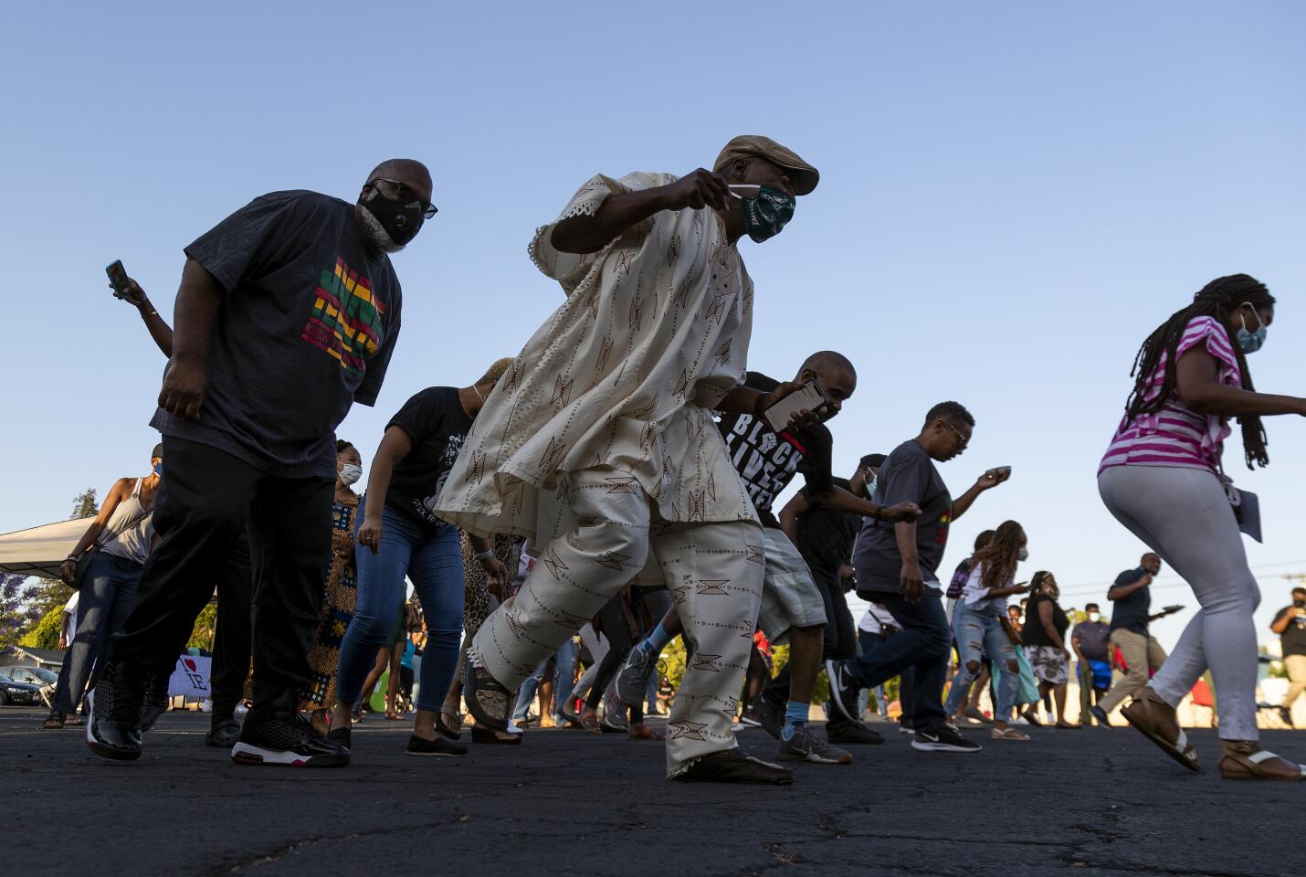 People gather for a group dance to enjoy the Juneteenth Freedom Celebration in Riverside