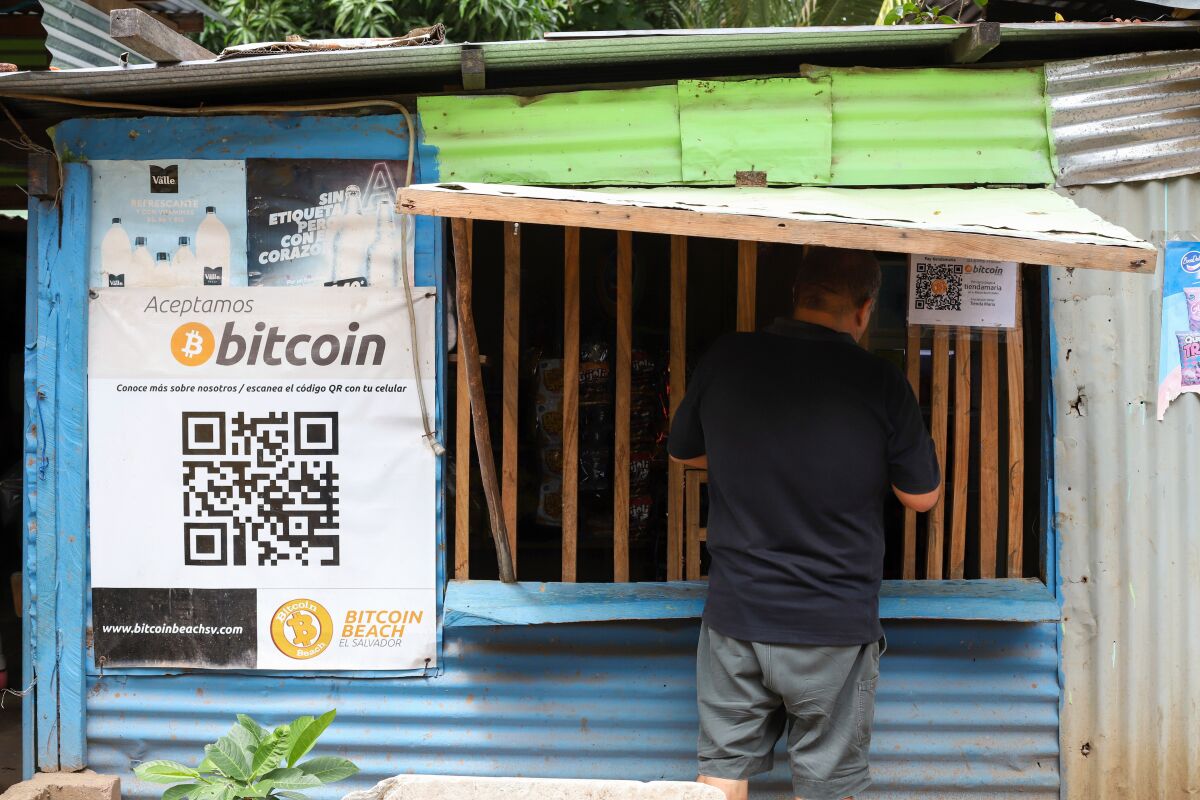 A sign by a window in El Salvador reads in Spanish, "We accept bitcoin."