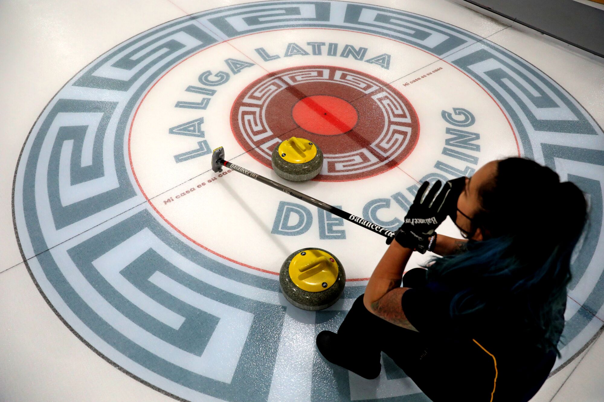 Kristina Lugo, of Oakland, a volunteer, shouts out commands to students at a Learn to Curl event.