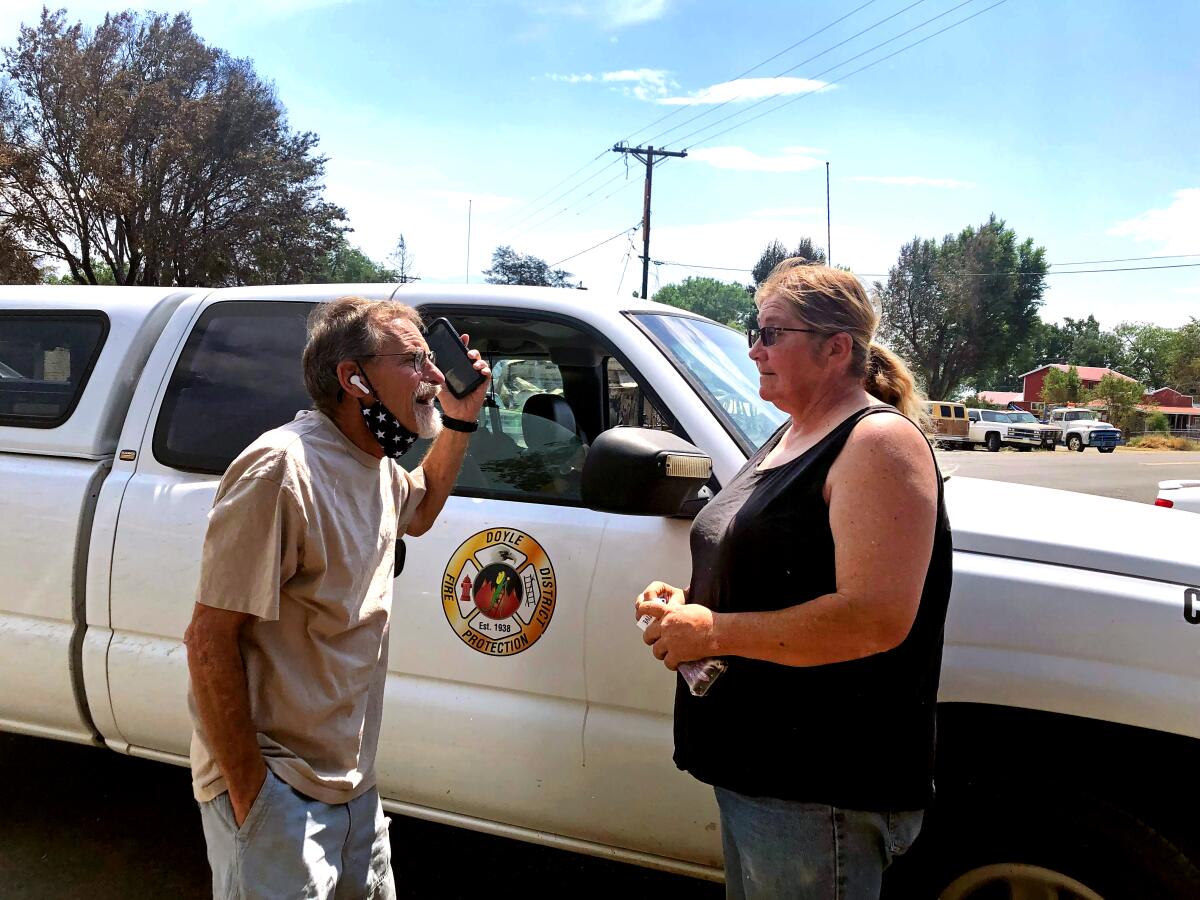 A man and woman talk next to a van