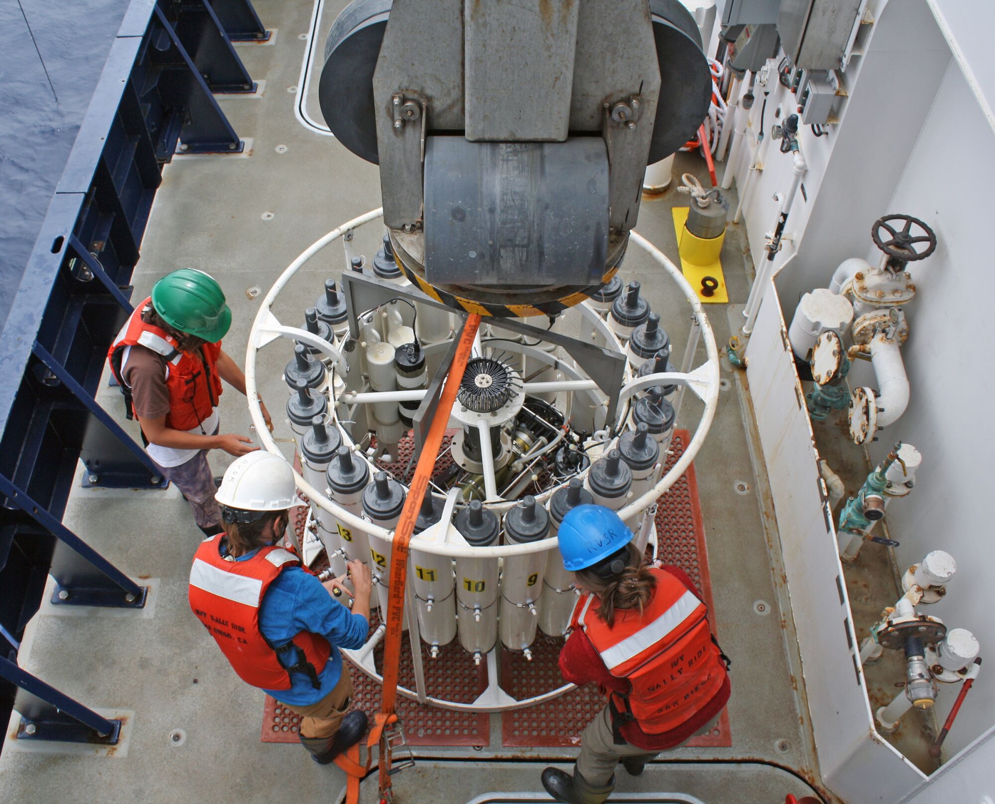Members of the all women CalCOFI research team deploy equipment and working in labs aboard the ship.