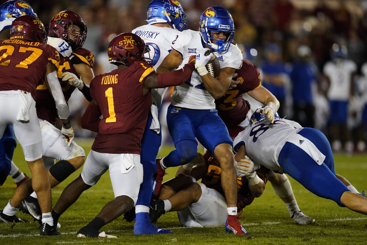 Kansas' Torry Locklin (12) is tackled by Iowa State defensive back Isheem Young (1) during the first half of an NCAA college football game, Saturday, Oct. 2, 2021, in Ames, Iowa. (AP Photo/Charlie Neibergall)