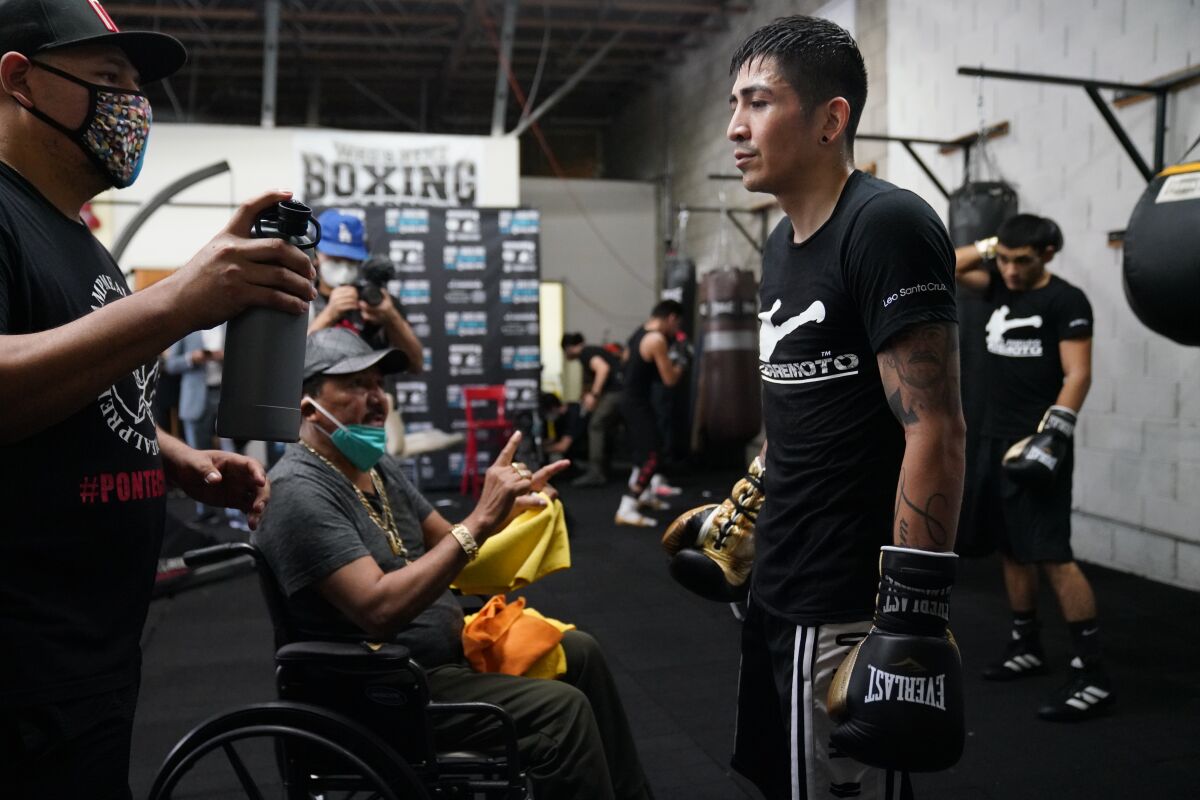 Leo Santa Cruz prepares to work out in front of the media while standing in front of his father, Jose, center.
