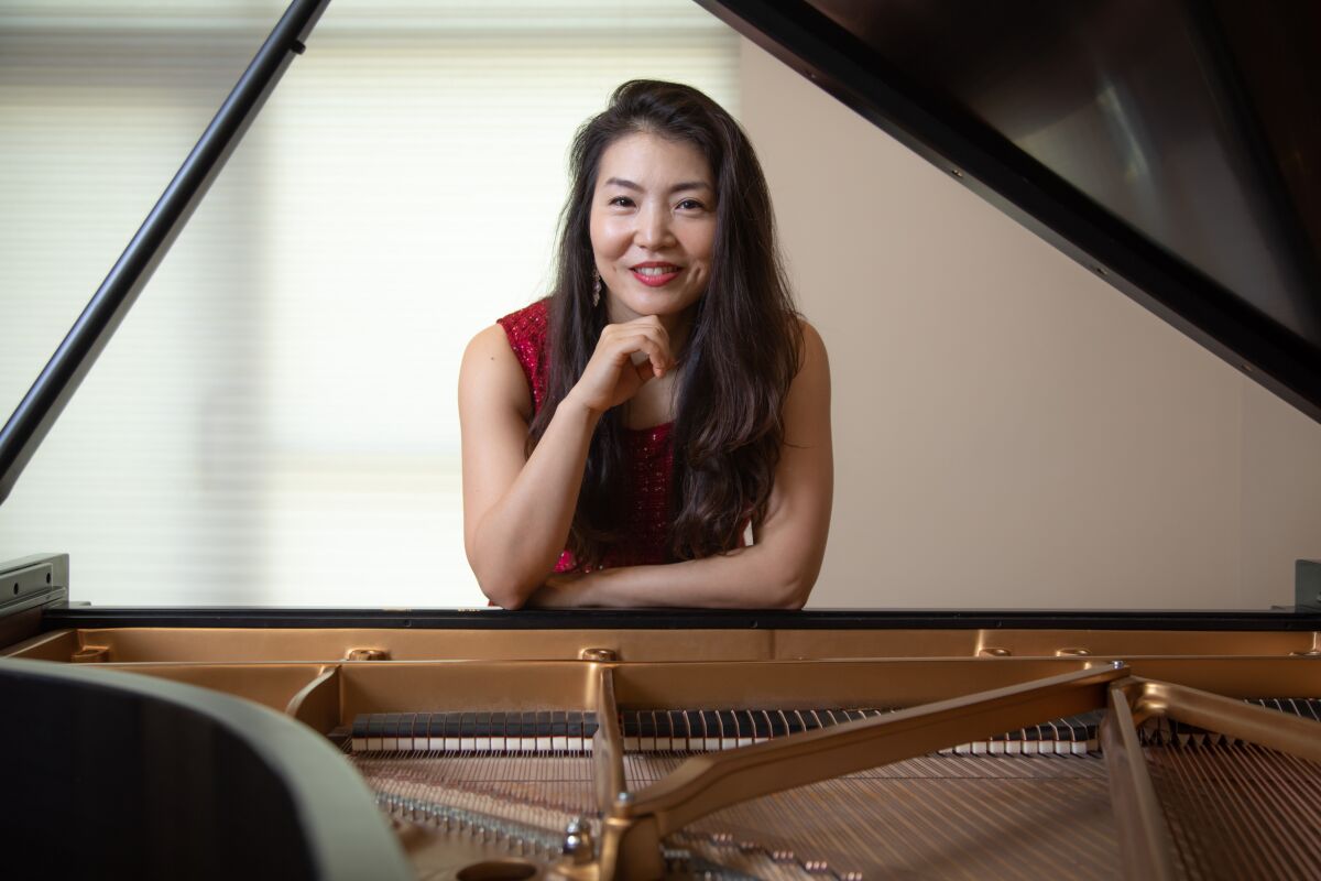 Classical pianist Jeeyoon Kim poses with her Steinway and Sons piano