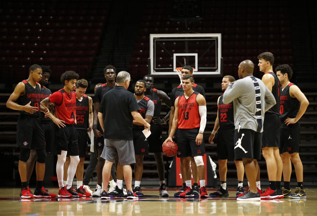 San Diego State University basketball coach Brian Dutcher, center, talks with the Aztecs during a practice on Sept. 26, 2019.