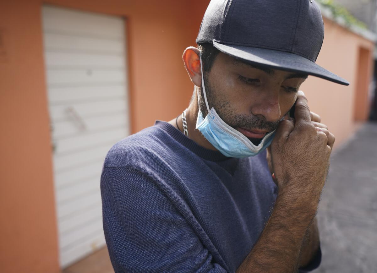 El venezolano José Cuicas escucha un mensaje de audio en su celular en el exterior de un albergue 
