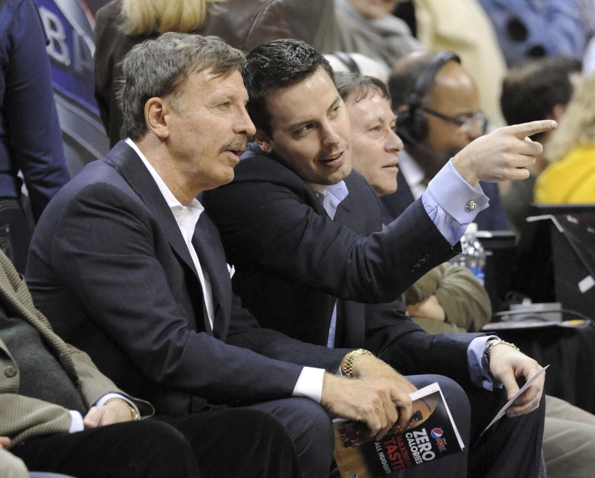 Stan Kroenke and his son, Josh, wear sports coats on the sideline while watching the Nuggets play 