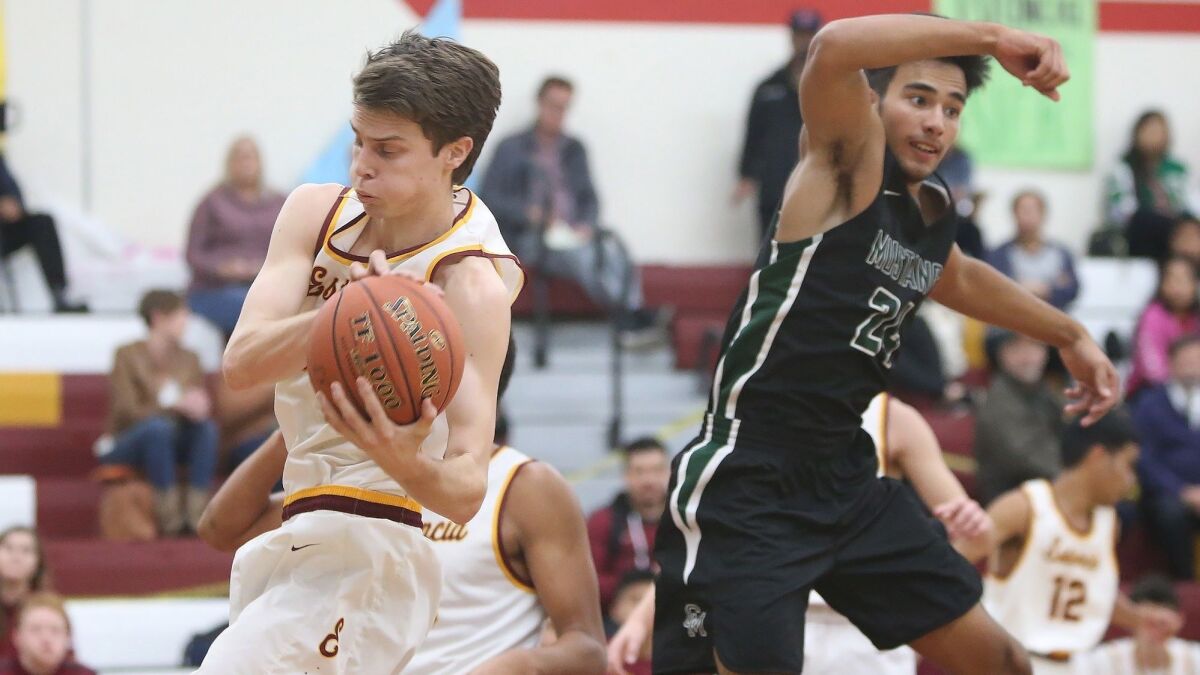 Estancia High's Jake Covey rebounds the ball away from Costa Mesa's Ethan Elliott during an Orange Coast League game on Wednesday.