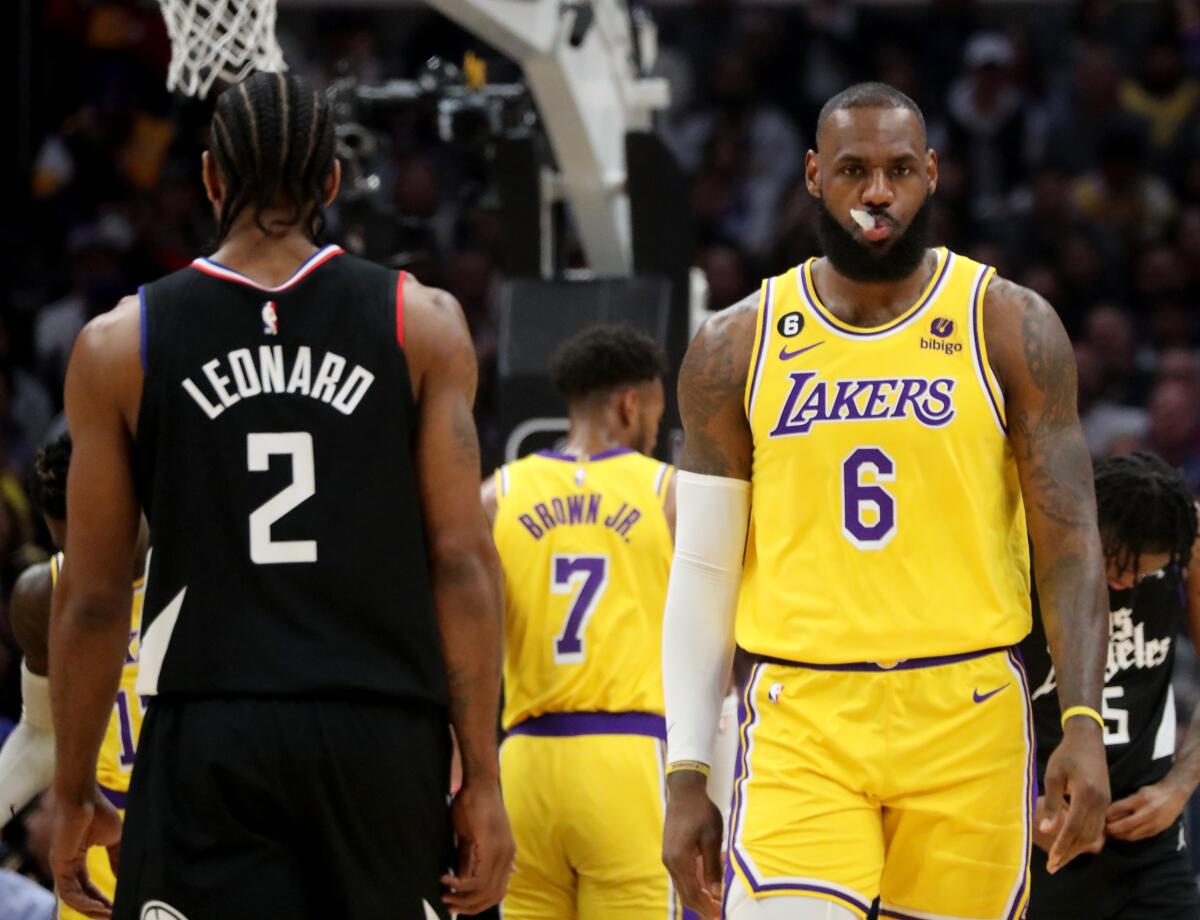 Clippers forward Kawhi Leonard and Lakers forward LeBron James walk past each other
