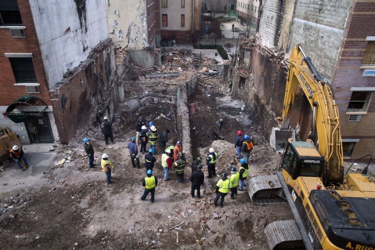 Workers excavate the area where two buildings once stood in Manhattan's East Harlem neighborhood. Investigators say they have discovered a leak in a gas main outside one of the buildings that was leveled in an explosion that killed eight people.