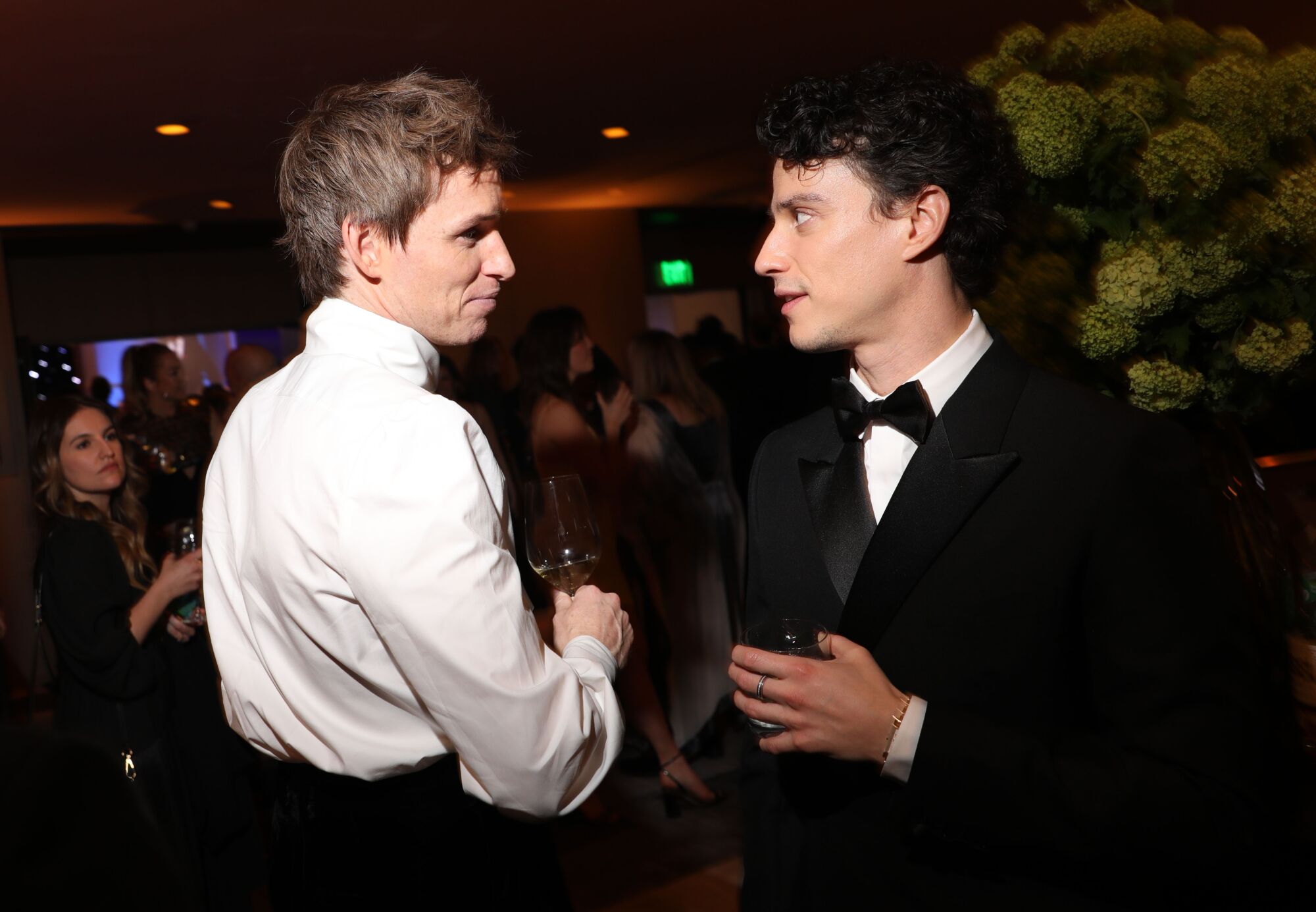 two young men in tuxes talk to each other 