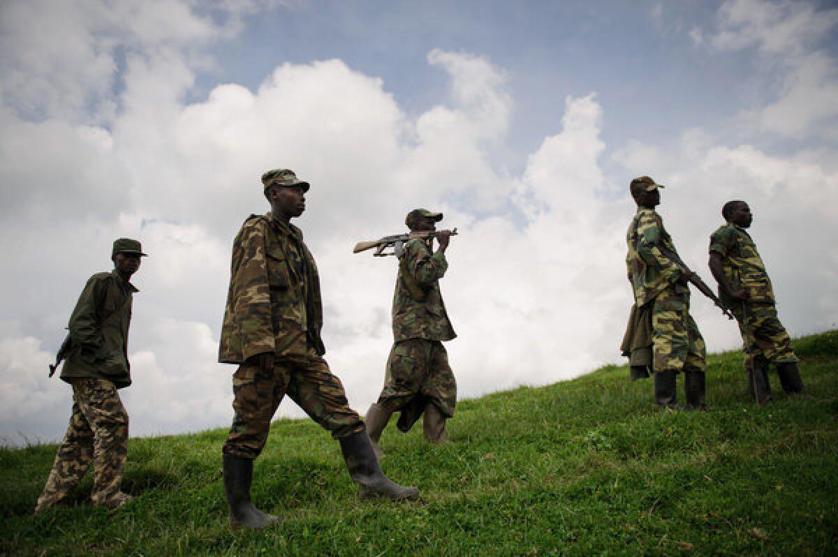 M23 rebels walk in the hills surrounding the town of Mushaki, in the Democratic Republic of Congo.