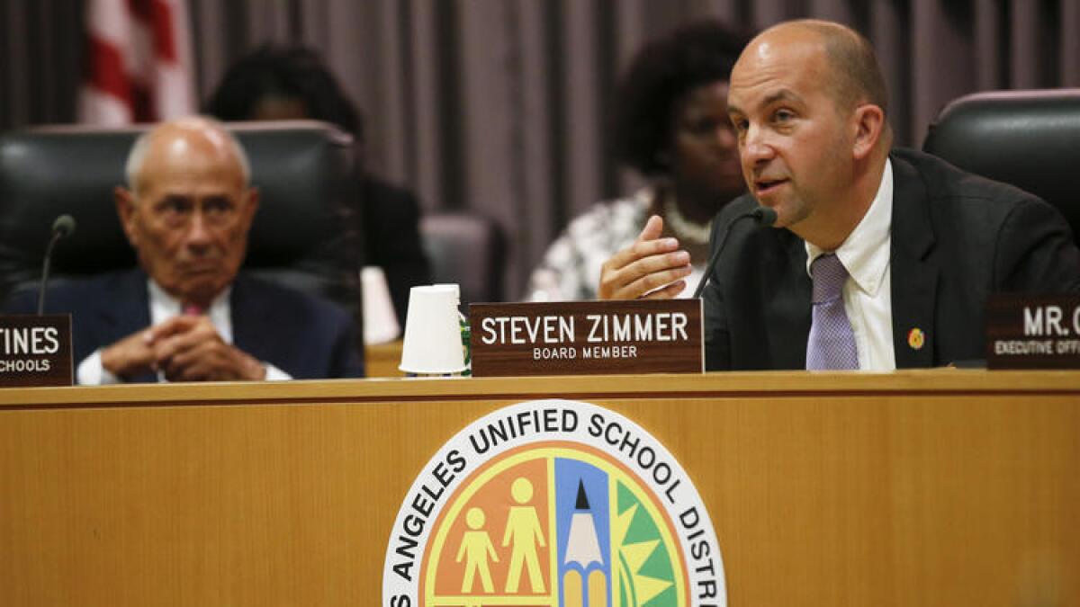 El presidente de la Junta Escolar del Distrito Escolar Unificado de Los Ángeles, Steven Zimmer, se dirige a los miembros de la junta, al lado el superintendente Ramón C. Cortines, sentado, en la reunión anual en la sede del distrito el pasado julio.