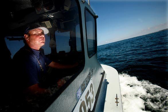 Keeping one eye on the horizon and the other on a GPS device, Tommy Pearson searches for a lost buoy off the Newport coast that marks the location of a string of shrimp traps he had set earlier.