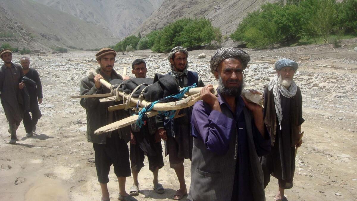 Afghan villagers carry the body of a flood victim in the Guzargah-e-Nur district of Baghlan province.