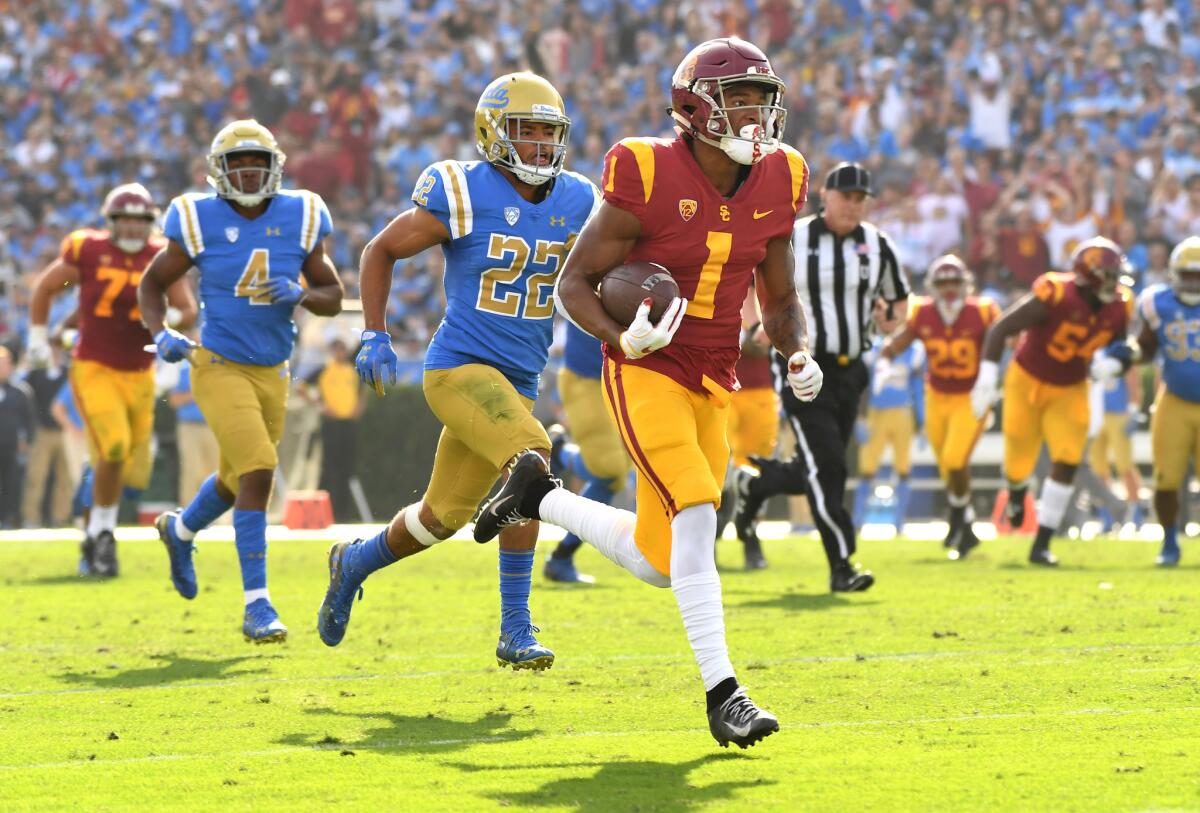 USC receiver Velus Jones Jr. sprints to the end zone for a touchdown as UCLA defensive back Nate Meadors gives chase in the second quarter at the Rose Bowl on Nov. 17, 2018.