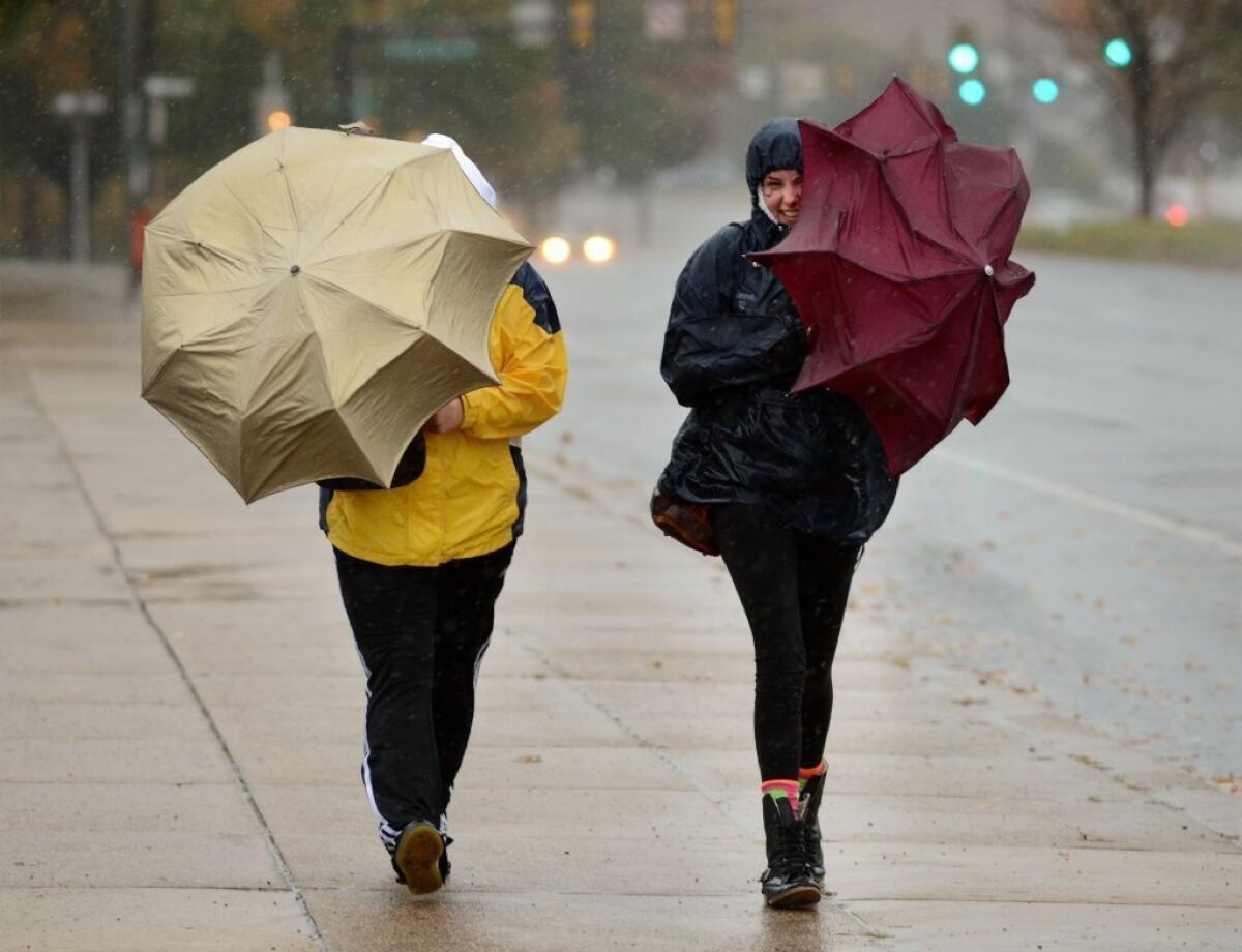 Two women make their way through the rain Monday in Philadelphia. The city was counting itself lucky, despite widespread power outages, as the effects of the storm were not devastating.