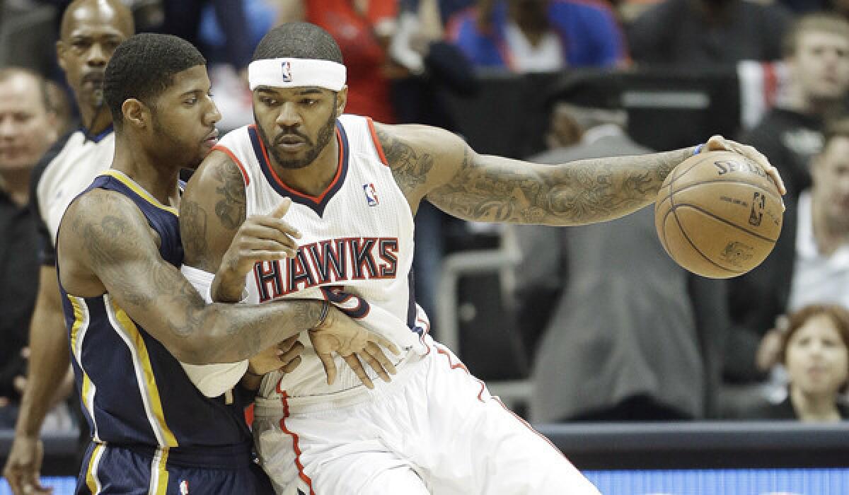 Atlanta Hawks forward Josh Smith moves the ball against Indiana Pacers forward Paul George during a game in April. Smith has agreed to a new deal with the Detroit Pistons.
