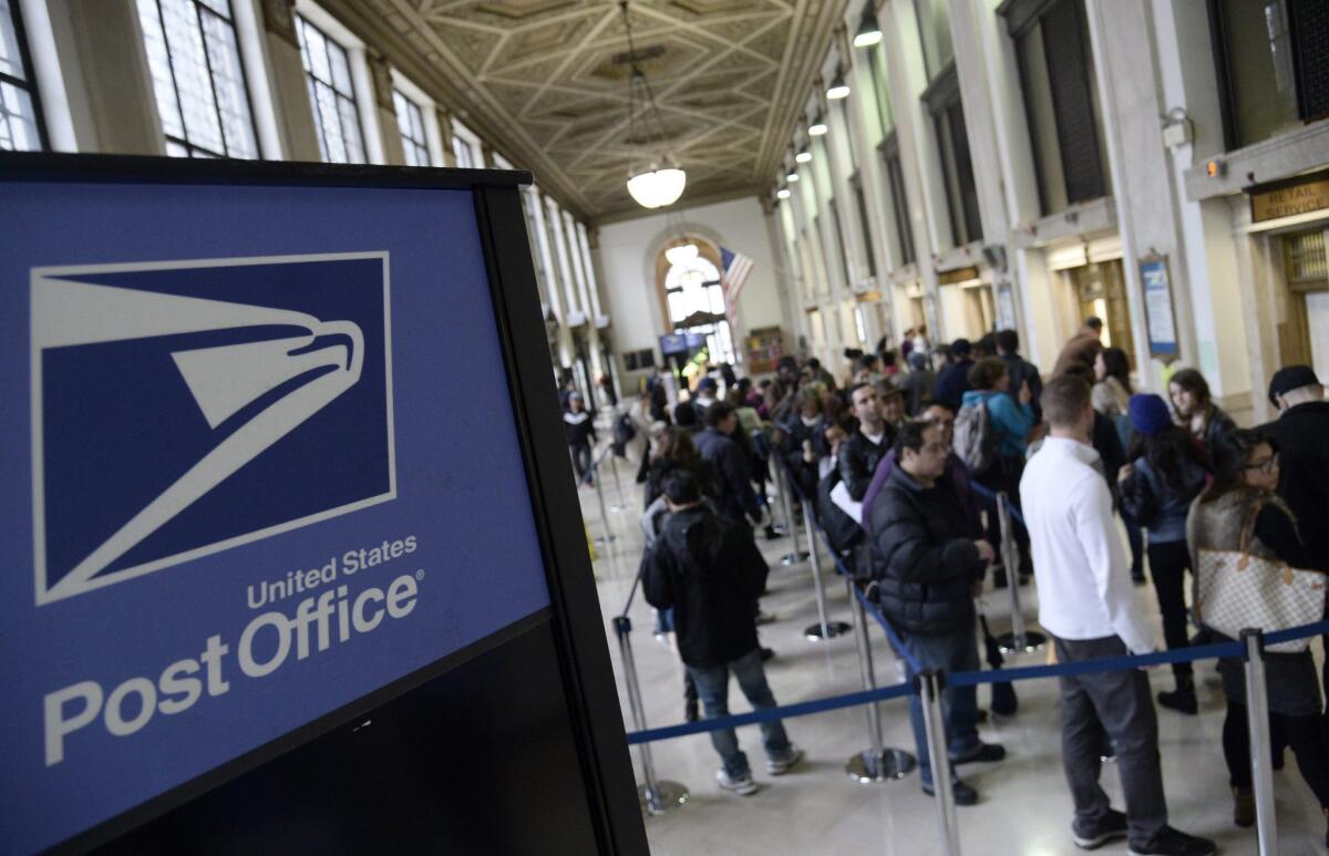 People wait in line to mail their income tax returns at a post office in New York City on Tuesday.
