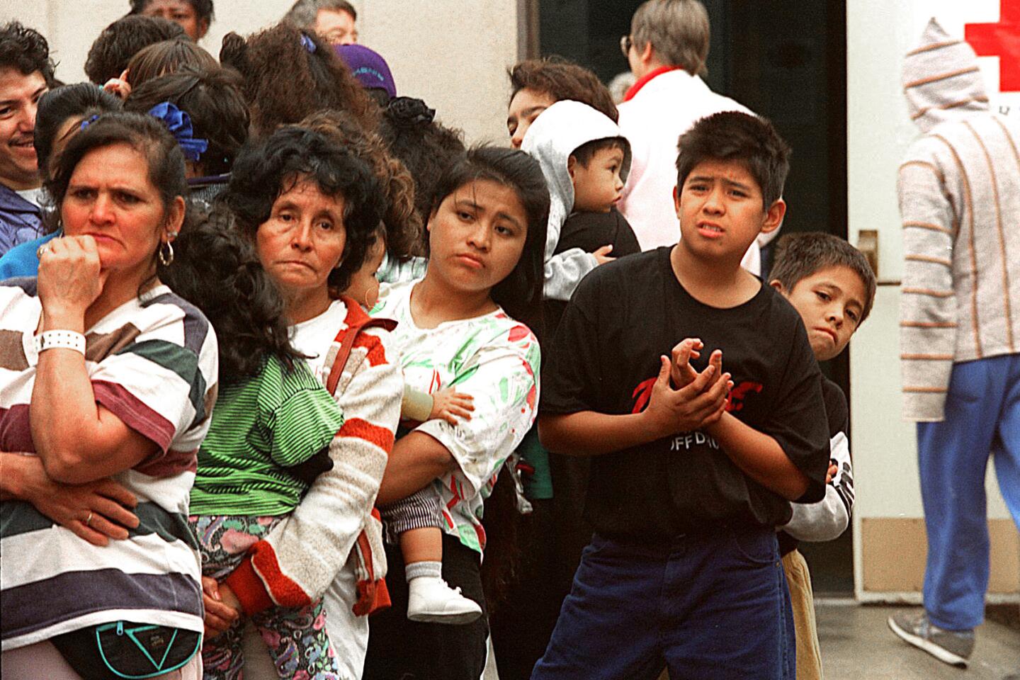 People stand in line at a Canoga Park High School shelter to pick up children's sweat suits donated by a sporting goods manufacturer.